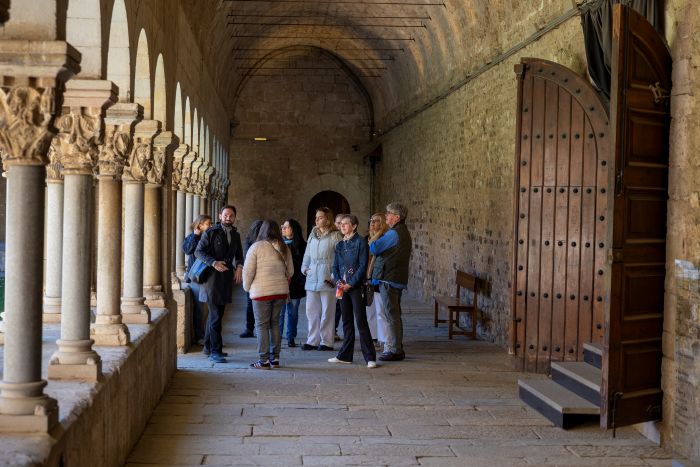 Grup fent una visita guiada pel claustre del Monestir de Sant Cugat