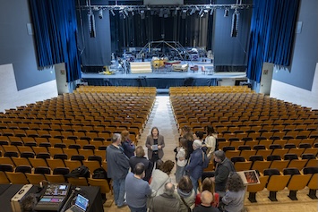 Grup de persones en una visita guiada en l'interior del Teatre Auditori, davant de l'escenari