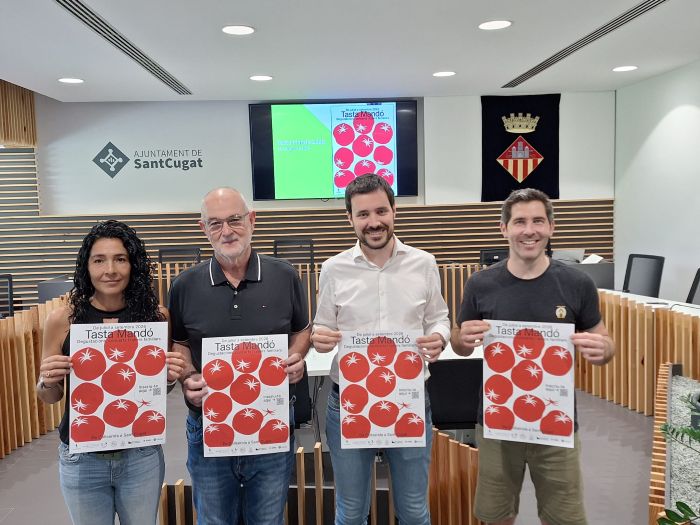Quatre persones ensenyant el cartell del Tasta Mandó 2026