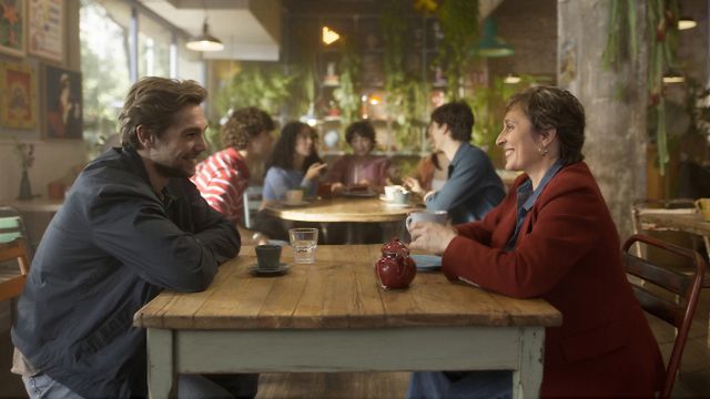 Un noi i una dona parlant cara a cara en un cafè.